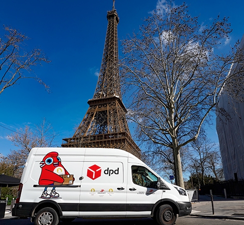 camion DPD habillé Jeux Olympiques et Paralympiques de Paris 2024devant la tour eiffel