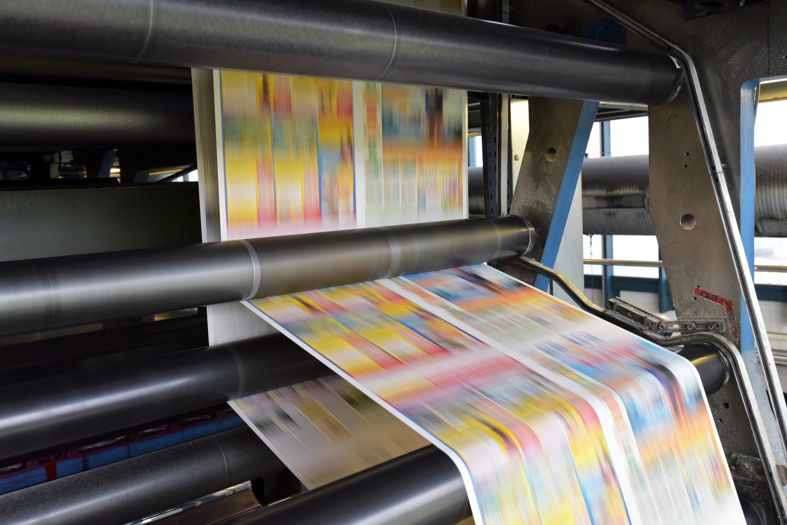 Machine d’impression industrielle produisant des documents en couleur à grande vitesse.